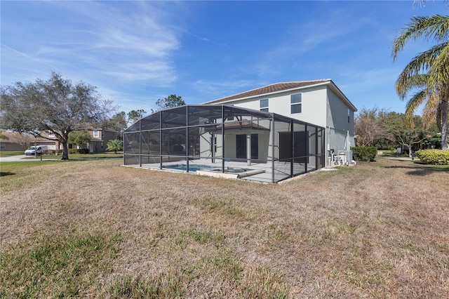 back of property featuring a yard, glass enclosure, and a patio area