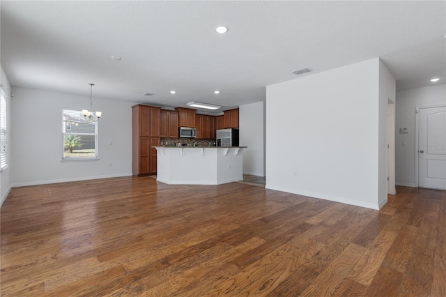 unfurnished living room with dark hardwood / wood-style floors and a notable chandelier