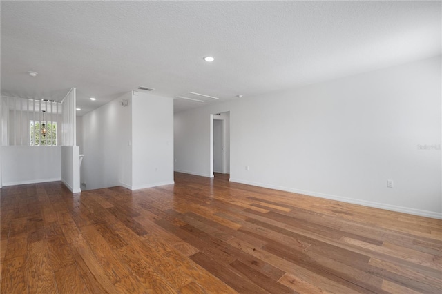 spare room with hardwood / wood-style floors and a textured ceiling