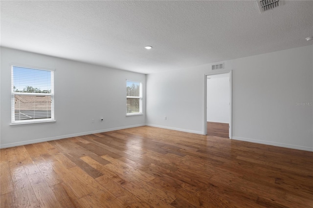 unfurnished room featuring hardwood / wood-style floors and a textured ceiling