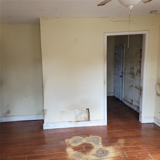 spare room featuring ceiling fan, dark hardwood / wood-style floors, and a textured ceiling