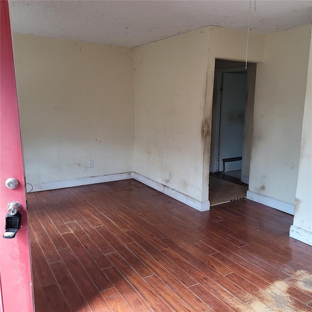 unfurnished room with dark hardwood / wood-style flooring