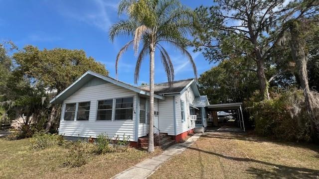 view of front of property featuring driveway and an attached carport