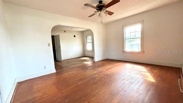 spare room with dark hardwood / wood-style flooring and ceiling fan