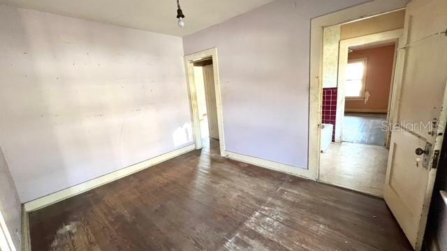 unfurnished bedroom with dark wood-type flooring