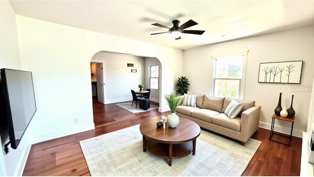 214 N New Hampshire Ave, Tavares, FL 32778 - living area with arched walkways, ceiling fan, wood finished floors, and baseboards
