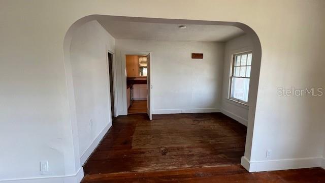214 N New Hampshire Ave, Tavares, FL 32778 - empty room with arched walkways, wood finished floors, and baseboards