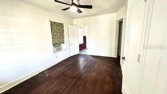 214 N New Hampshire Ave, Tavares, FL 32778 - unfurnished bedroom featuring dark wood finished floors, baseboards, cooling unit, a ceiling fan, and ornamental molding