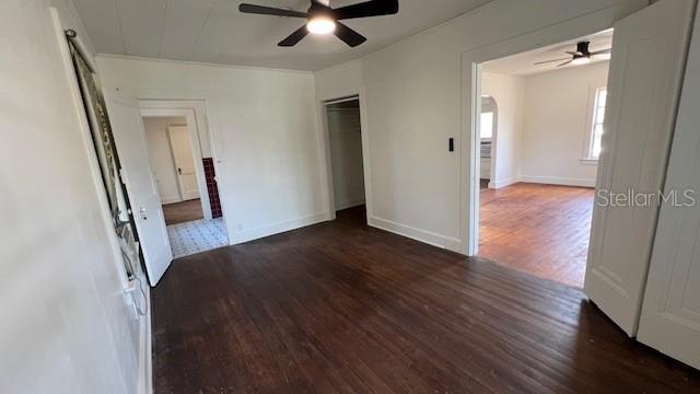 214 N New Hampshire Ave, Tavares, FL 32778 - unfurnished bedroom featuring wood finished floors, a closet, a ceiling fan, and baseboards