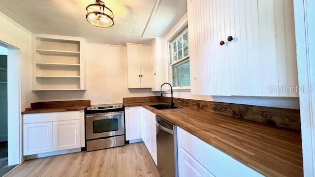 214 N New Hampshire Ave, Tavares, FL 32778 - kitchen featuring stainless steel appliances, wooden counters, a sink, white cabinetry, and light wood-type flooring