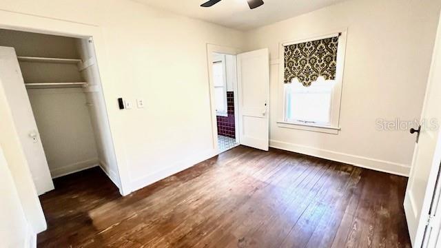214 N New Hampshire Ave, Tavares, FL 32778 - unfurnished bedroom featuring baseboards, dark wood finished floors, a closet, and ceiling fan