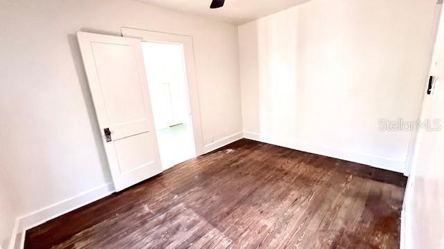 214 N New Hampshire Ave, Tavares, FL 32778 - unfurnished room featuring dark wood-type flooring, a ceiling fan, and baseboards