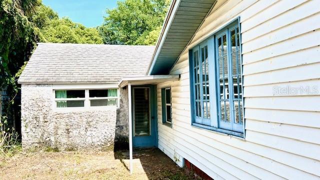 214 N New Hampshire Ave, Tavares, FL 32778 - view of side of property featuring roof with shingles and stone siding
