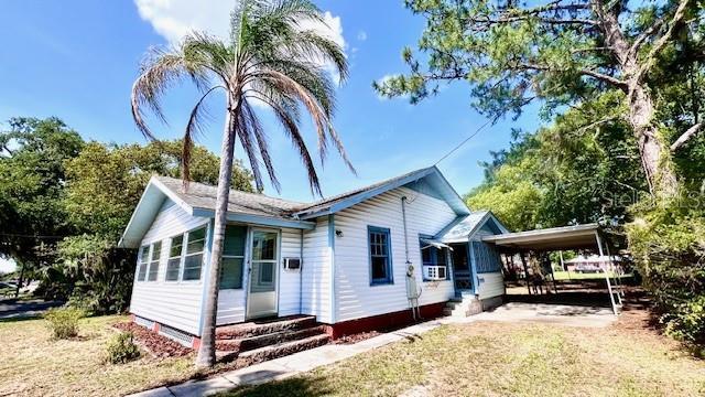 214 N New Hampshire Ave, Tavares, FL 32778 - view of side of property featuring entry steps and an attached carport