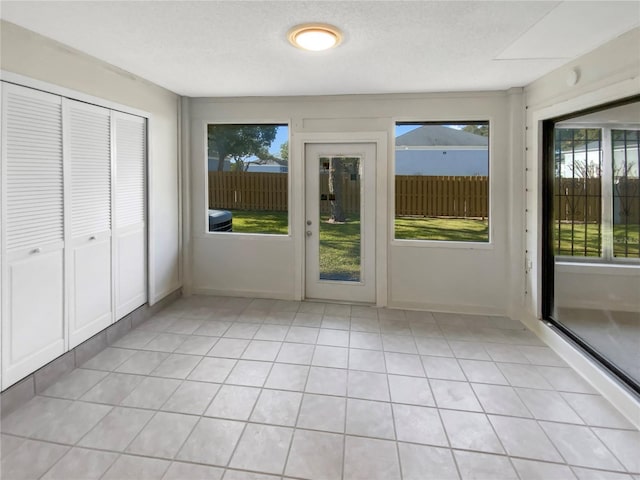 interior space featuring light tile patterned flooring and a textured ceiling