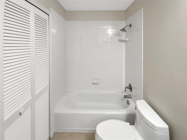 bathroom with tiled shower / bath, tile patterned floors, and toilet