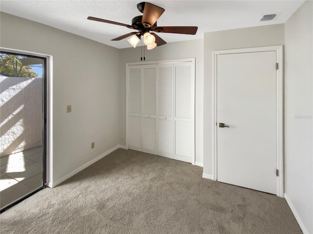 unfurnished bedroom with light carpet, a closet, and ceiling fan