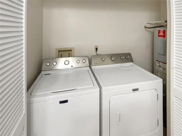 laundry area with separate washer and dryer and water heater