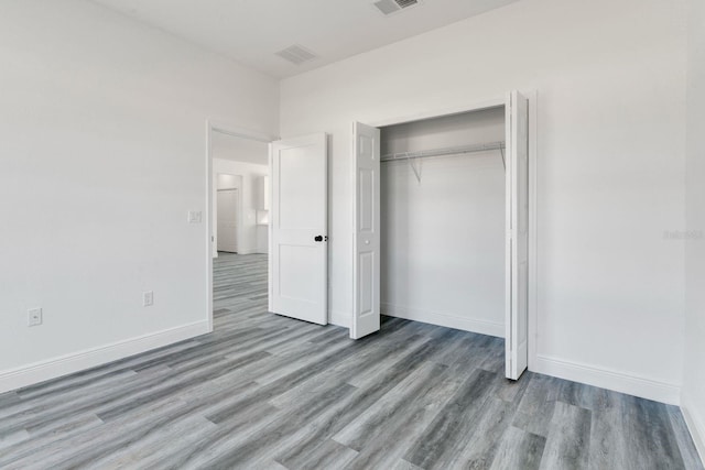 unfurnished bedroom with light hardwood / wood-style floors and a closet