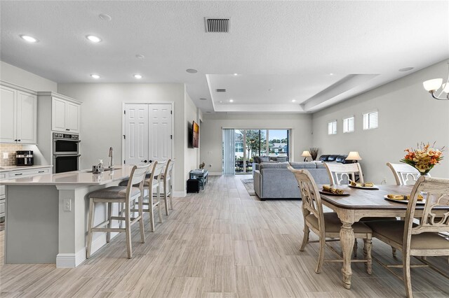 8456 Norwich Way, Mount Dora, FL 32757 - dining area featuring recessed lighting, light wood-style floors, baseboards, and a raised ceiling