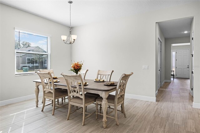 8456 Norwich Way, Mount Dora, FL 32757 - dining room with a chandelier, baseboards, and light wood-style flooring