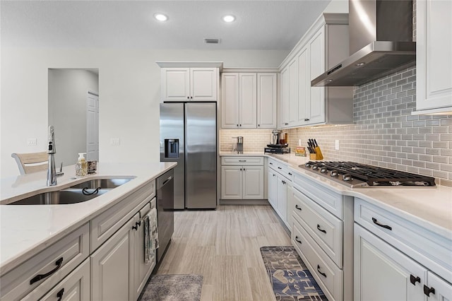 8456 Norwich Way, Mount Dora, FL 32757 - kitchen featuring wall chimney range hood, stainless steel appliances, a sink, backsplash, and white cabinetry