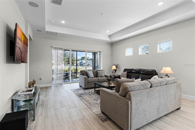 8456 Norwich Way, Mount Dora, FL 32757 - living room featuring a raised ceiling, baseboards, and recessed lighting