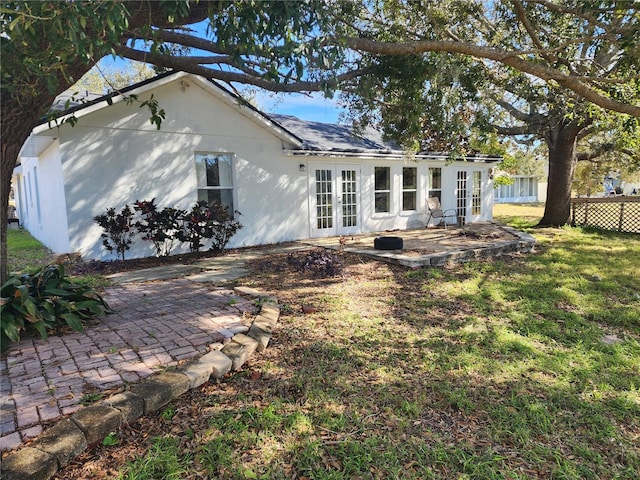 rear view of house with french doors, a yard, and a patio