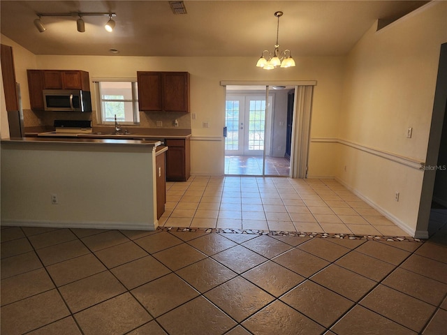 kitchen with range with electric stovetop, pendant lighting, sink, a chandelier, and light tile patterned floors