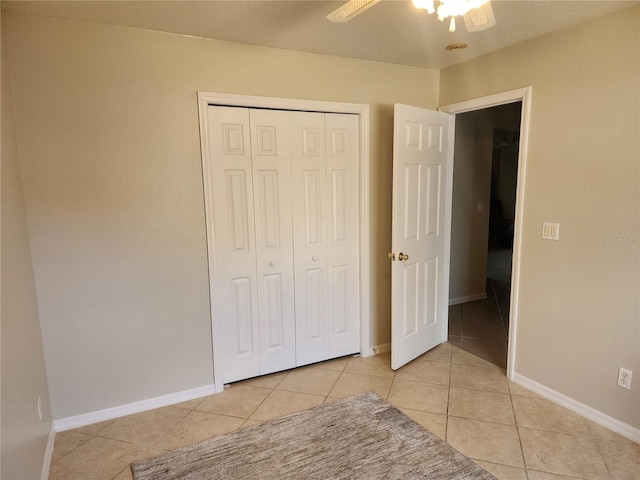 unfurnished bedroom featuring light tile patterned floors, ceiling fan, and a closet