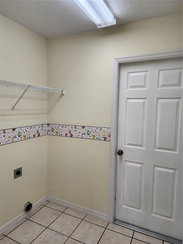 washroom featuring light tile patterned floors, hookup for an electric dryer, and a textured ceiling