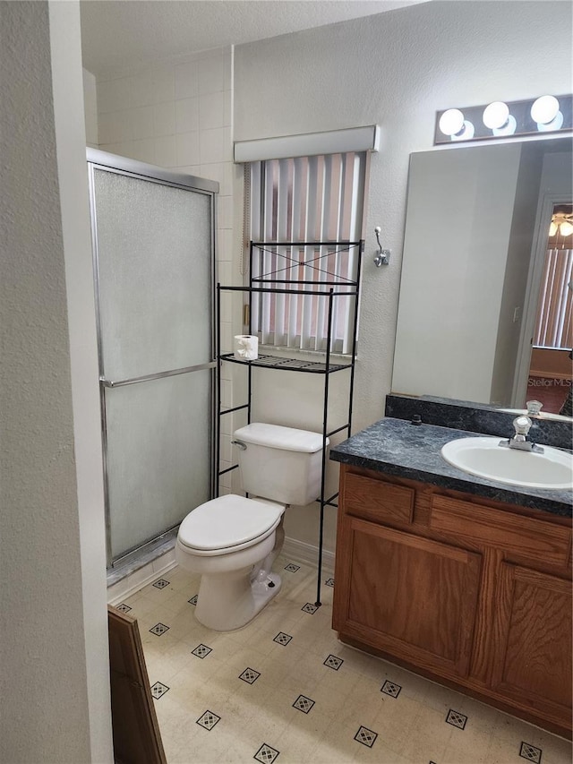 bathroom with vanity, toilet, and a shower with shower door