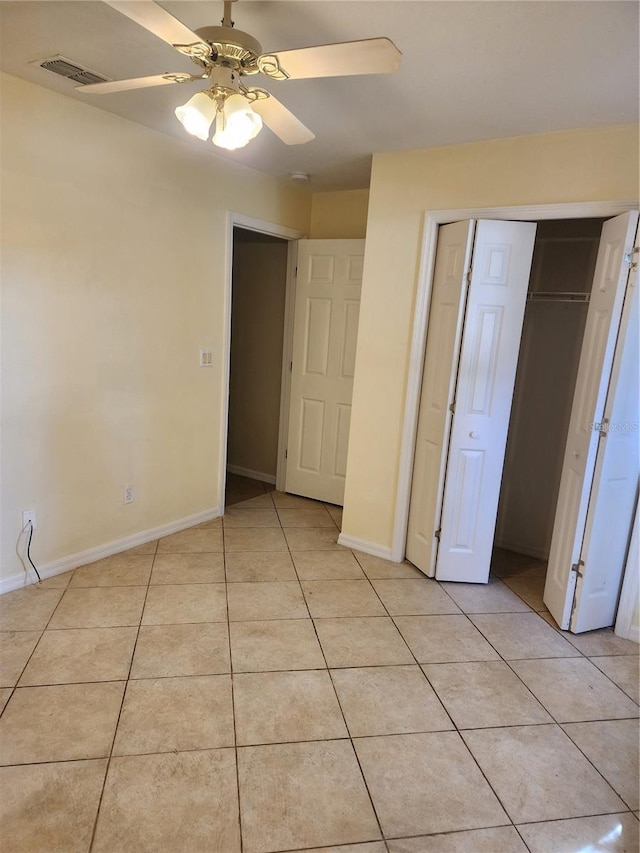 unfurnished bedroom featuring light tile patterned floors, a closet, and ceiling fan