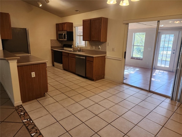 kitchen featuring tasteful backsplash, sink, light tile patterned flooring, and appliances with stainless steel finishes