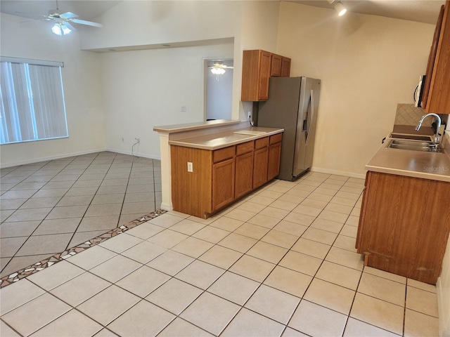 kitchen with stainless steel appliances, sink, light tile patterned floors, and ceiling fan