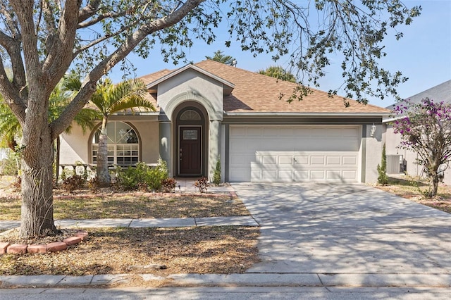 ranch-style home with central AC unit and a garage