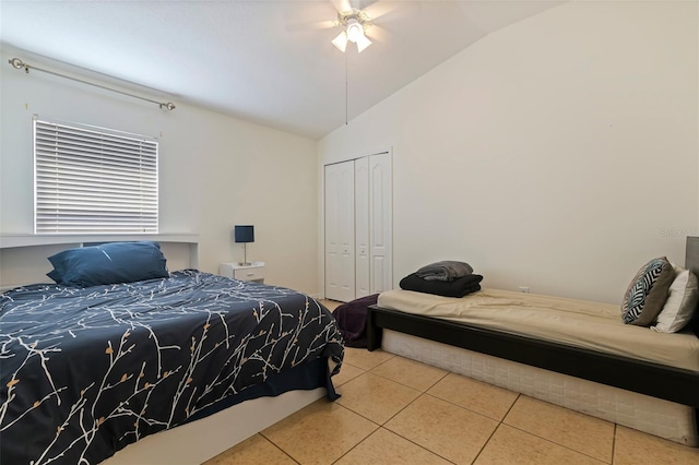 tiled bedroom featuring ceiling fan, lofted ceiling, and a closet