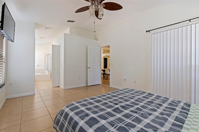 bedroom featuring vaulted ceiling, light tile patterned floors, ceiling fan, and ensuite bath