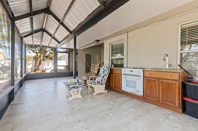 unfurnished sunroom featuring sink and vaulted ceiling