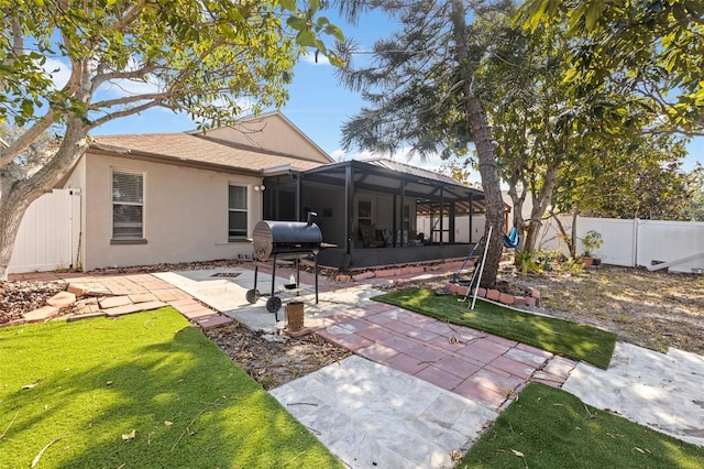 back of property with a patio, a lanai, and a yard