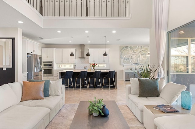 living room with a high ceiling, baseboards, and recessed lighting