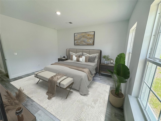 bedroom with wood-type flooring and multiple windows