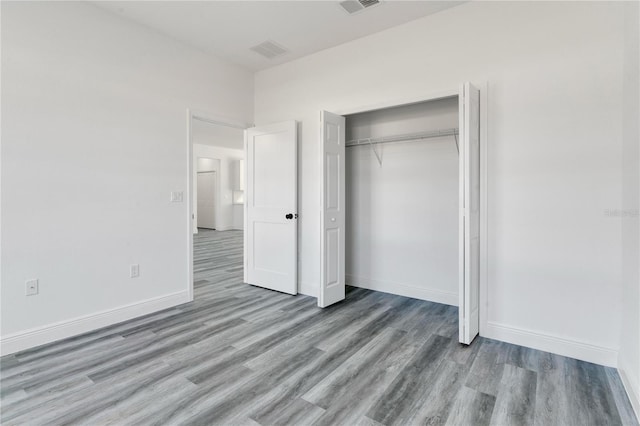 unfurnished bedroom with light wood-type flooring and a closet