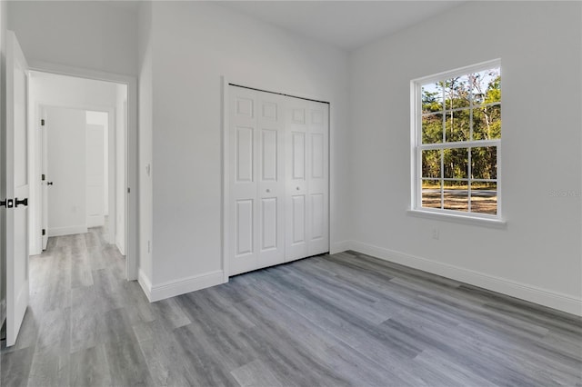 unfurnished bedroom featuring light hardwood / wood-style flooring and a closet