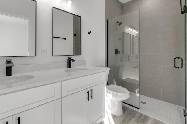 bathroom featuring vanity, an enclosed shower, wood-type flooring, and toilet