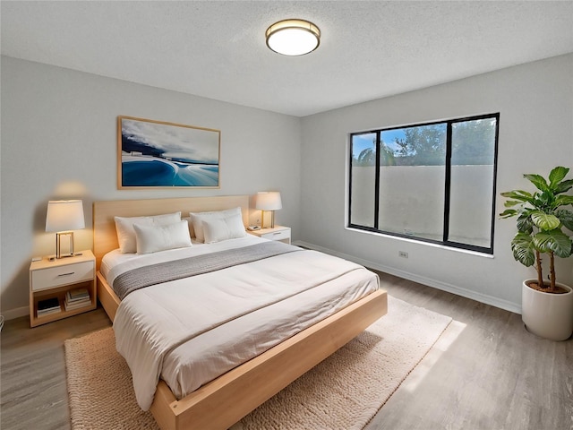 bedroom featuring wood-type flooring and a textured ceiling