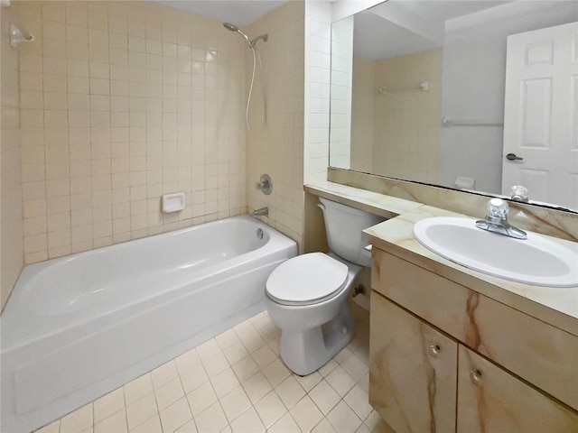 full bathroom featuring tile patterned flooring, tiled shower / bath, vanity, and toilet