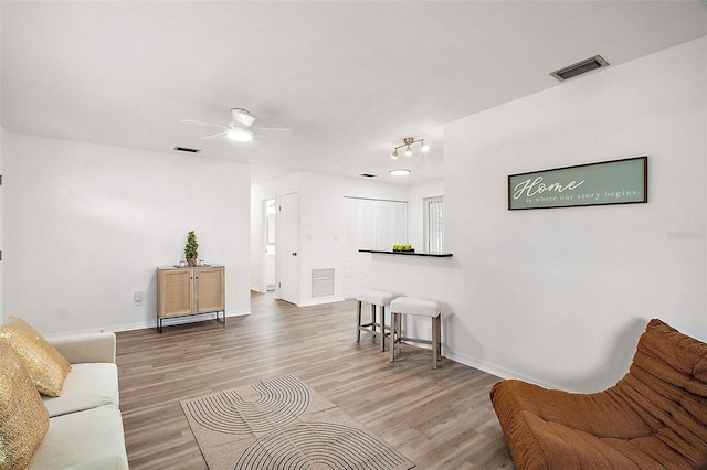 living room featuring hardwood / wood-style flooring and ceiling fan