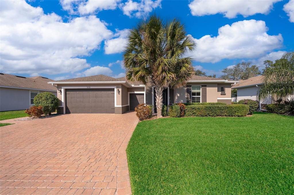 ranch-style home with a garage and a front yard