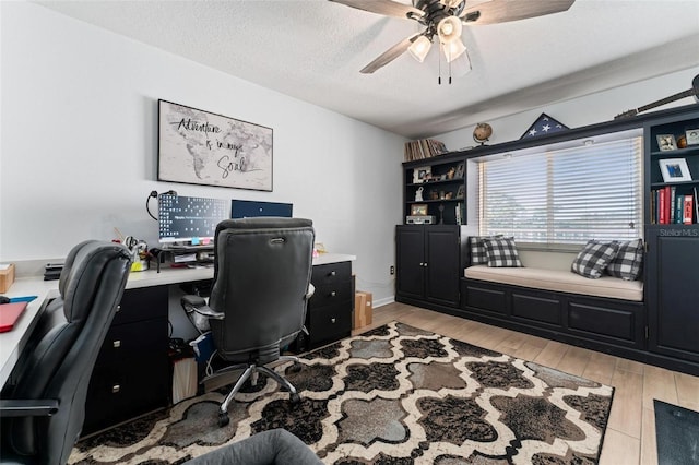 home office featuring ceiling fan, a textured ceiling, and light wood-type flooring